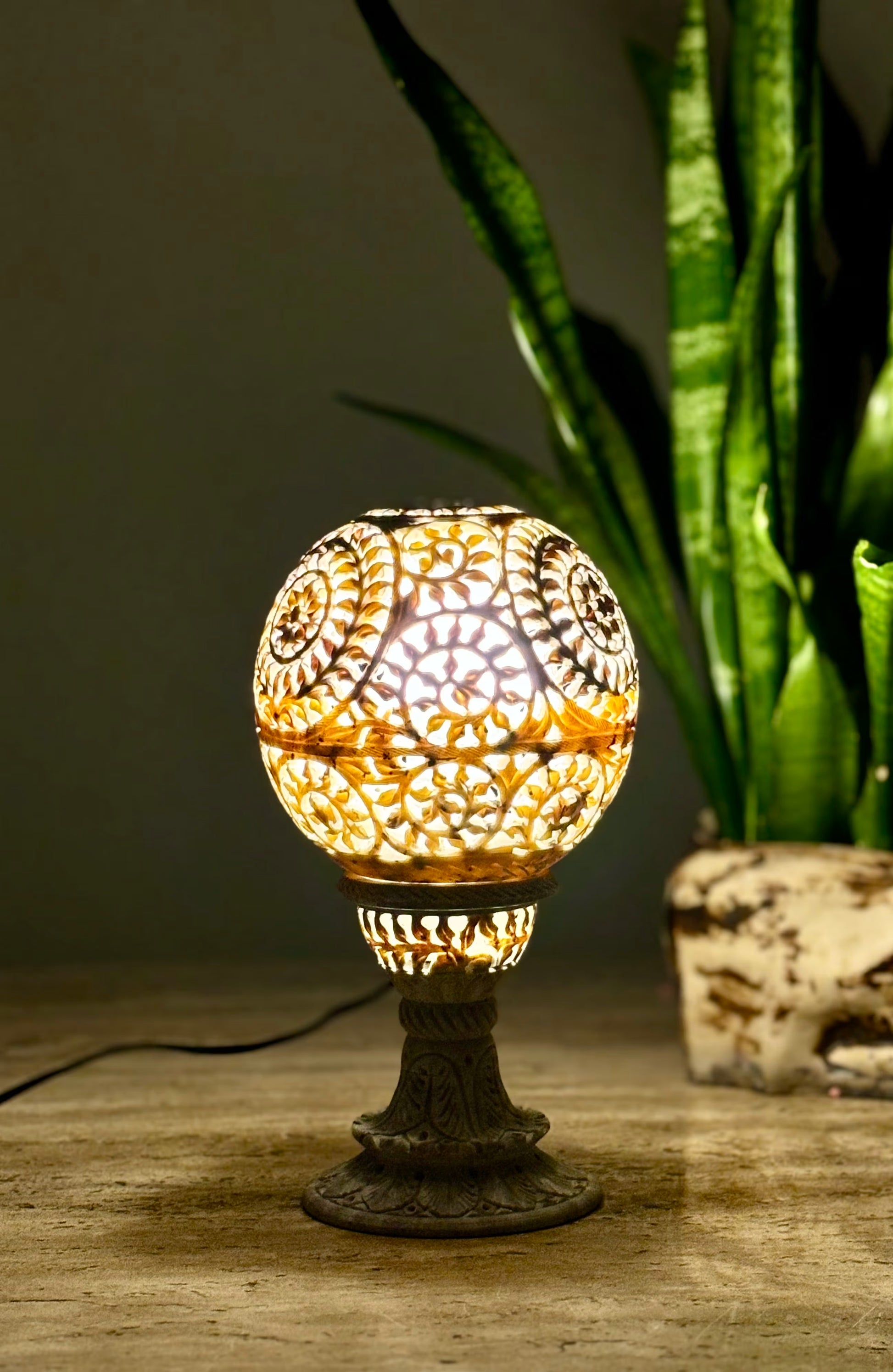 Decorative table lamp with intricate design on a wooden surface